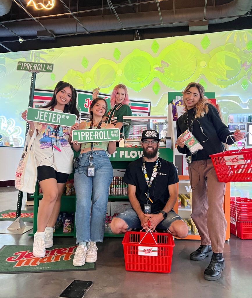 Five people pose in a store, holding street signs that say 