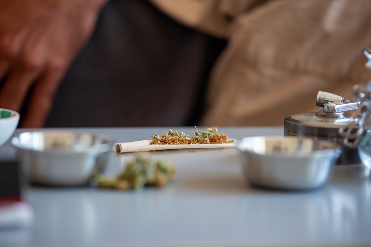 A gray table with a blunt in progress abd several silver dishes.