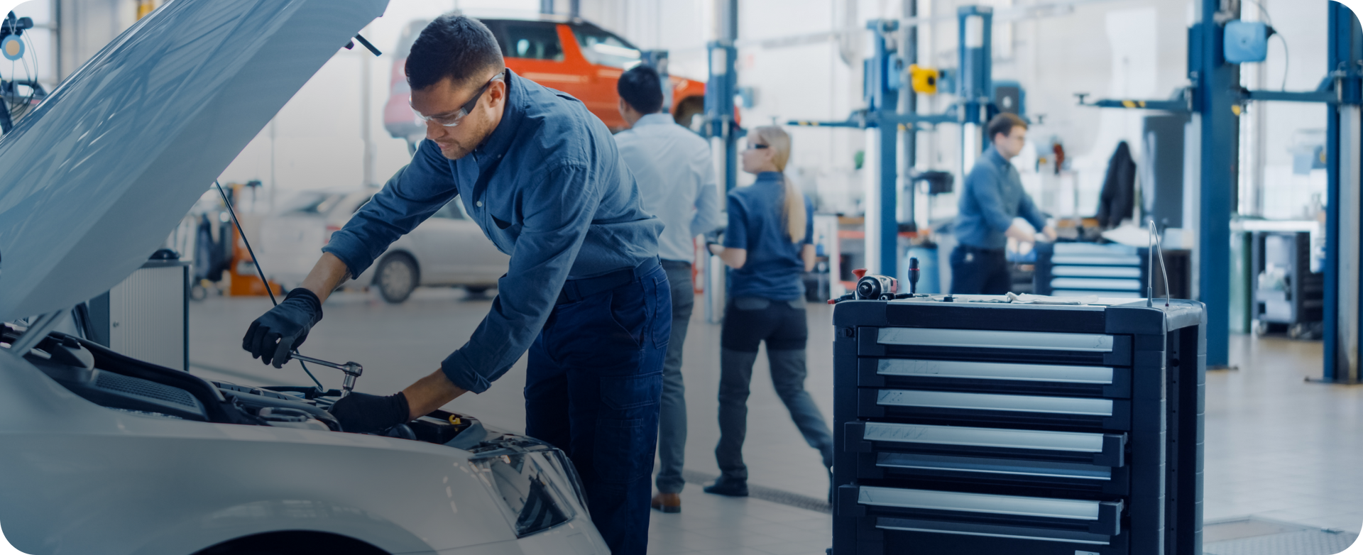Mechanic inspecting an open car hood in an auto repair shop, with tools and equipment nearby | A1 Brake & Service