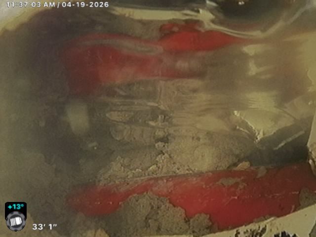 Blurry close-up of a red and gray rocky surface with a small on-screen HUD in the corner