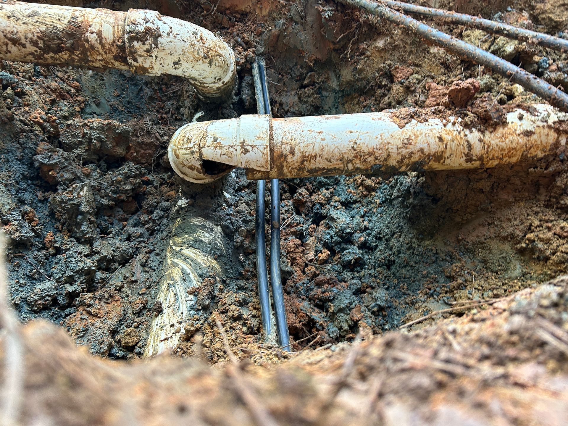 A close up of a broken pipe in the ground.