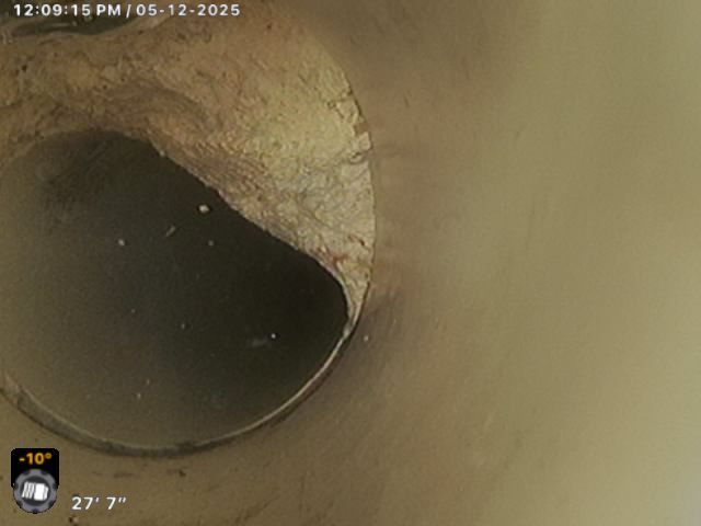 A close up of a drain with a time stamp of 12:05 pm