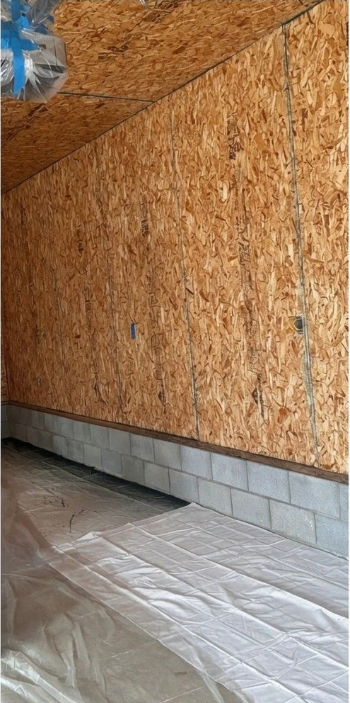 Vacuum cleaner and hose on a speckled floor in an empty room