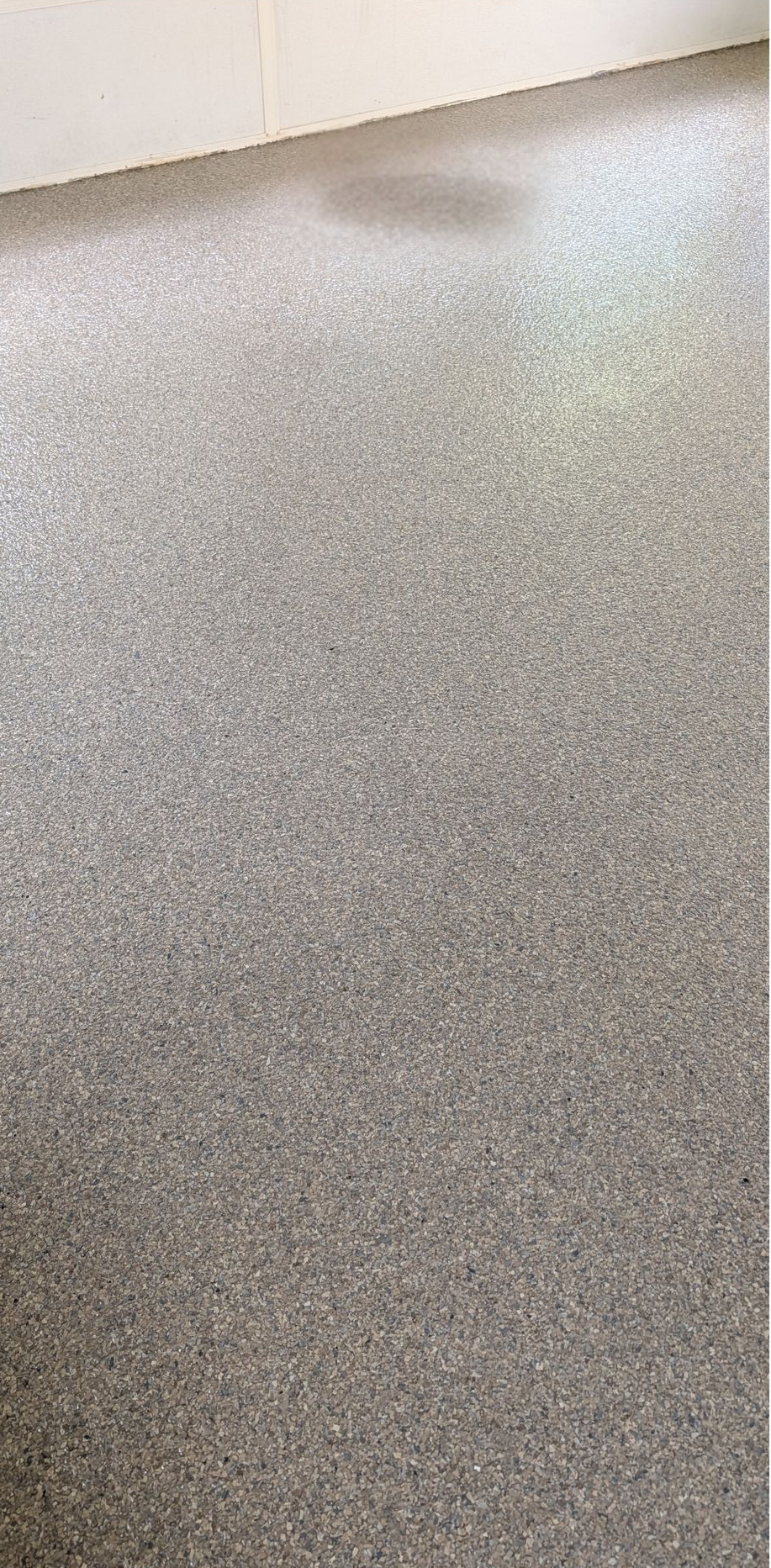 Speckled gray epoxy floor with a row of blue Lowe’s shopping carts in the background