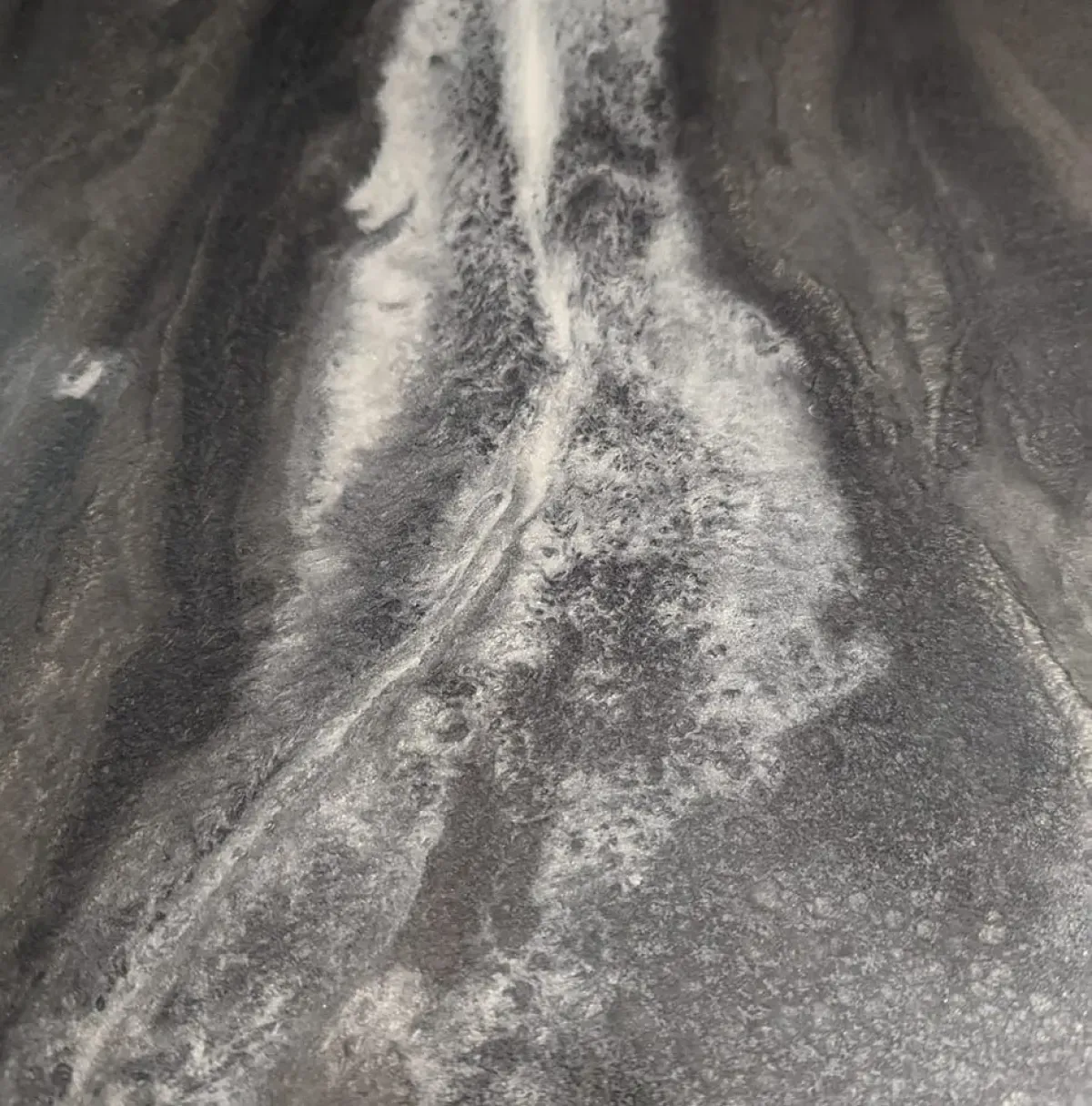 Aerial view of a winding river cutting through a dark, rocky landscape
