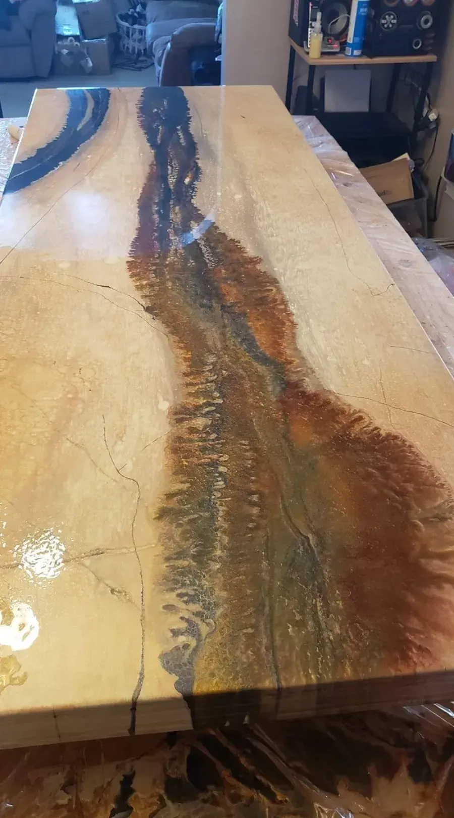 A polished wood table with a natural brown resin river running through the center.