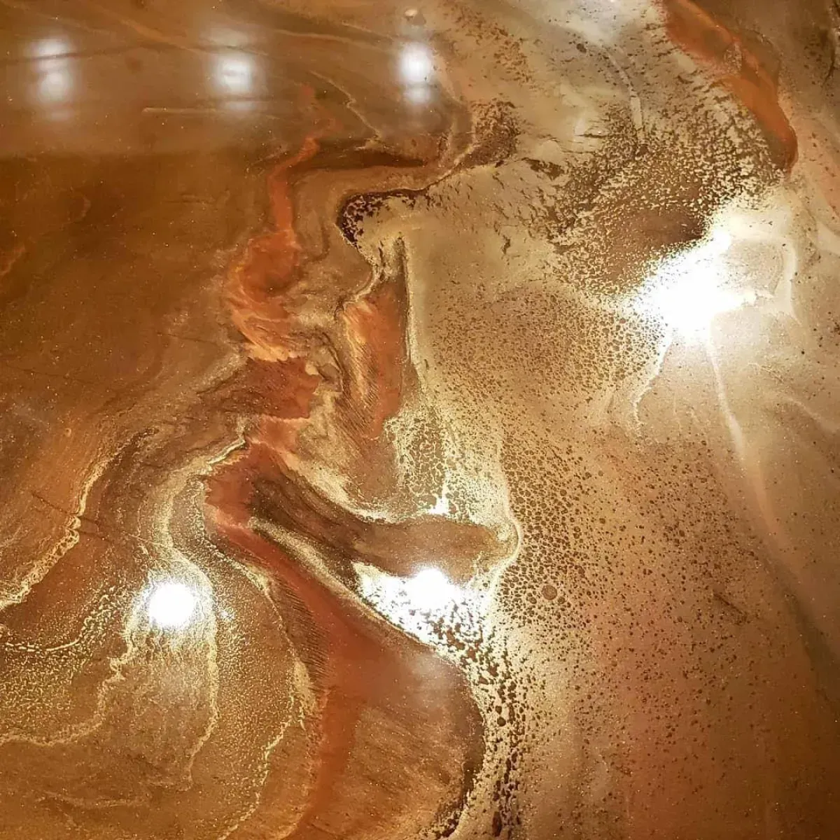 Abstract brown and gold marbled surface with bright reflective highlights