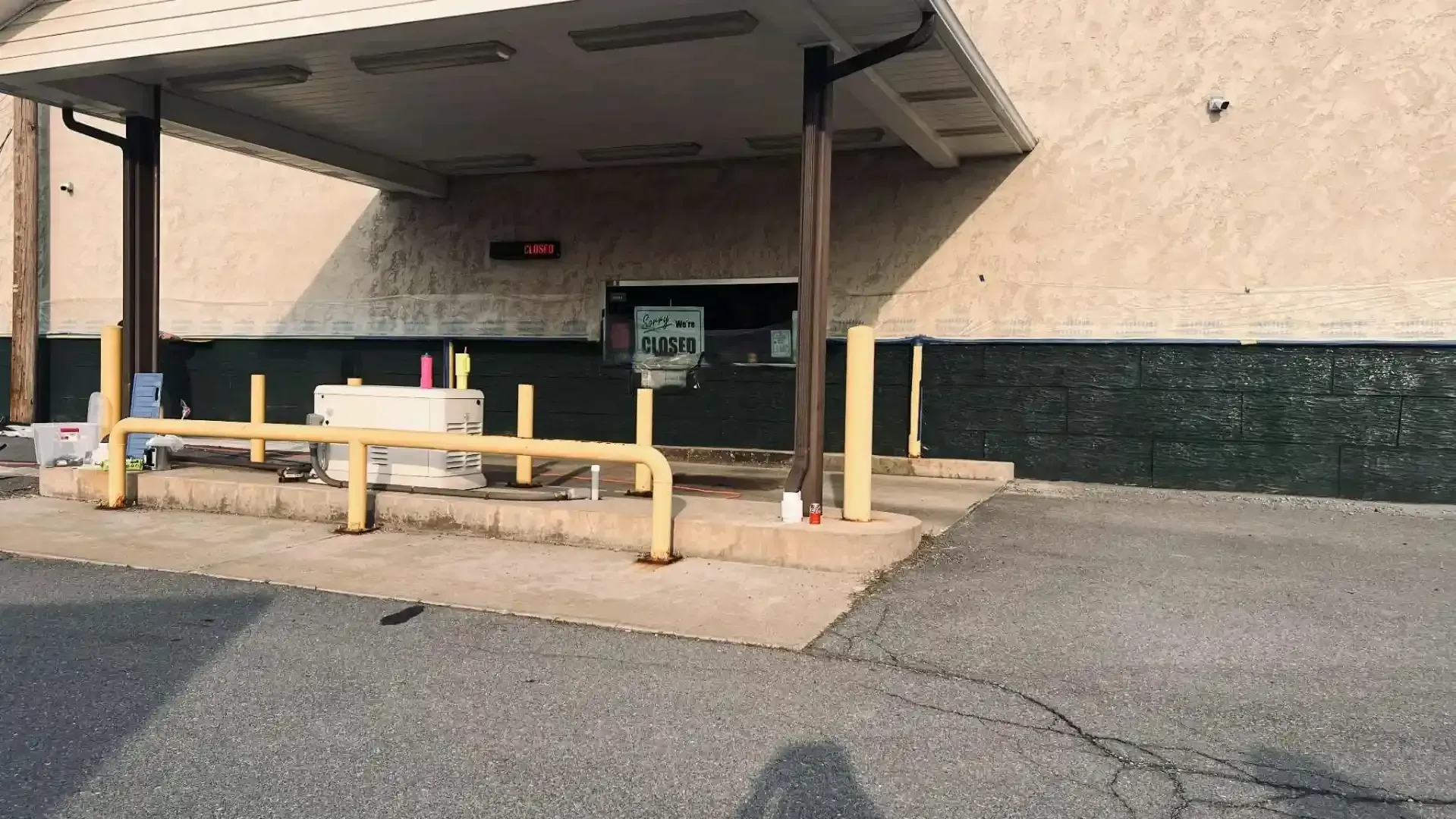 Storefront drive-thru with yellow railings and a covered pickup lane outside a beige building