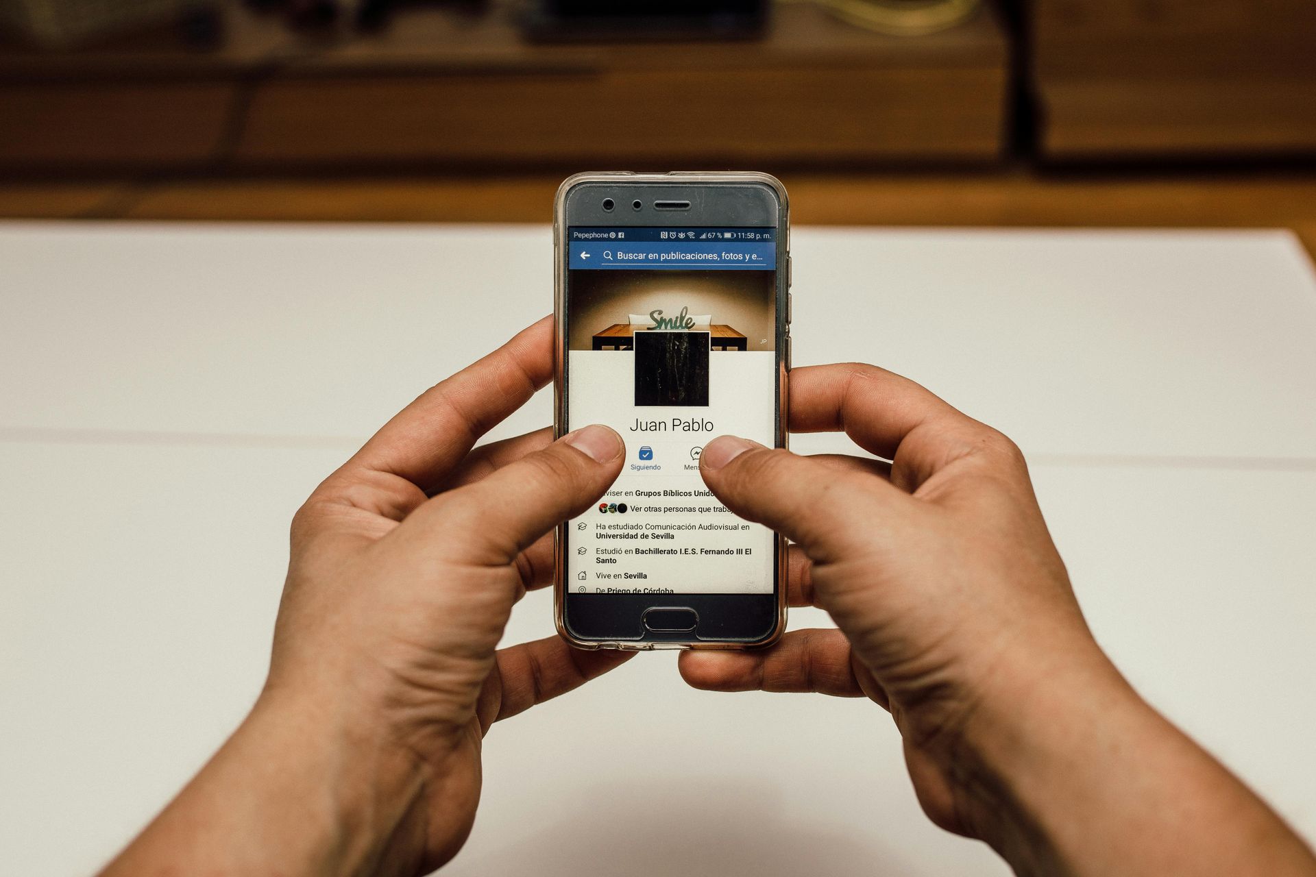 A person is holding a cell phone in their hands.