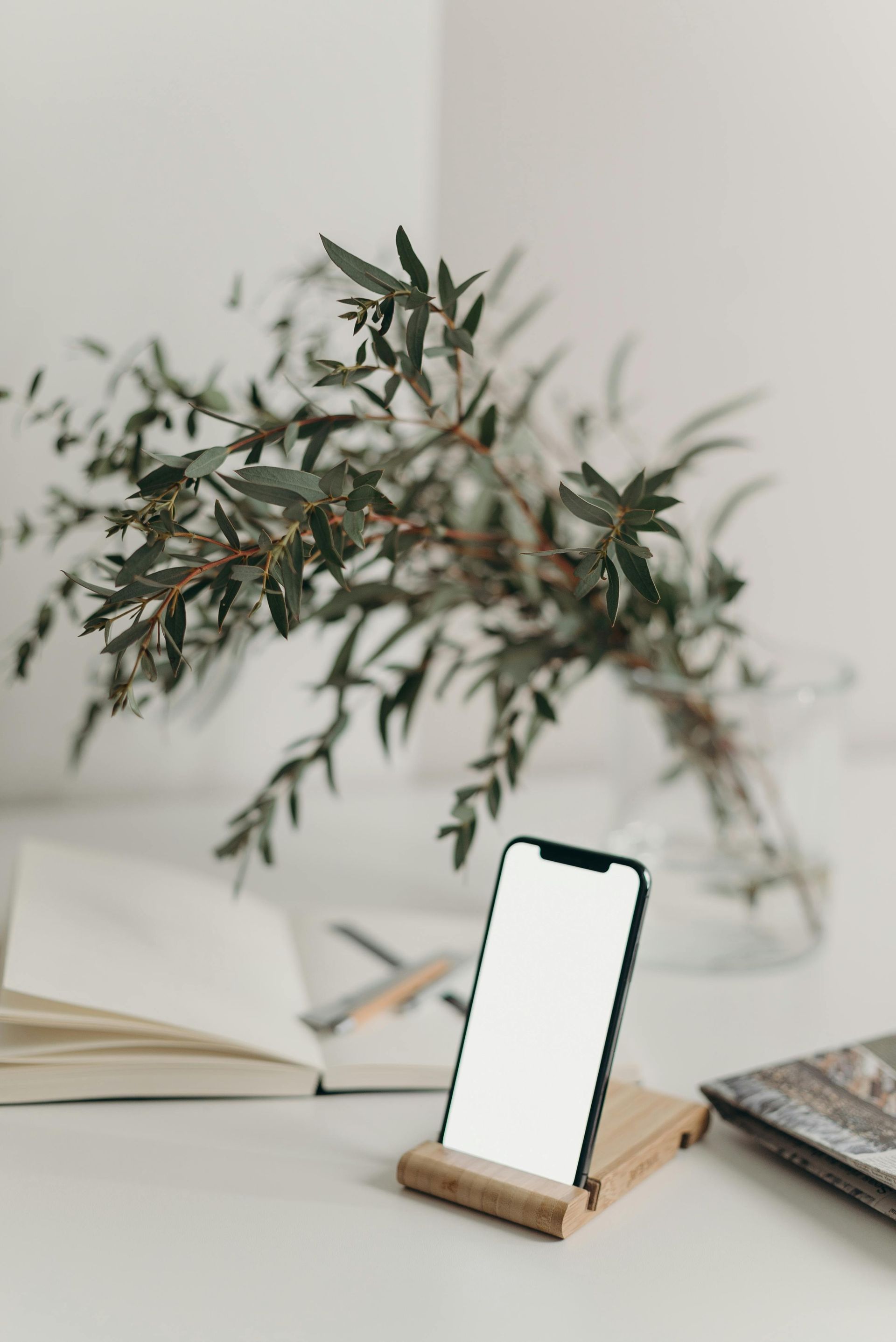 A cell phone is sitting on a wooden stand on a table.