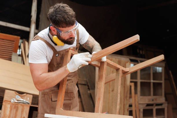 Carpenter sanding a custom wooden furniture piece.