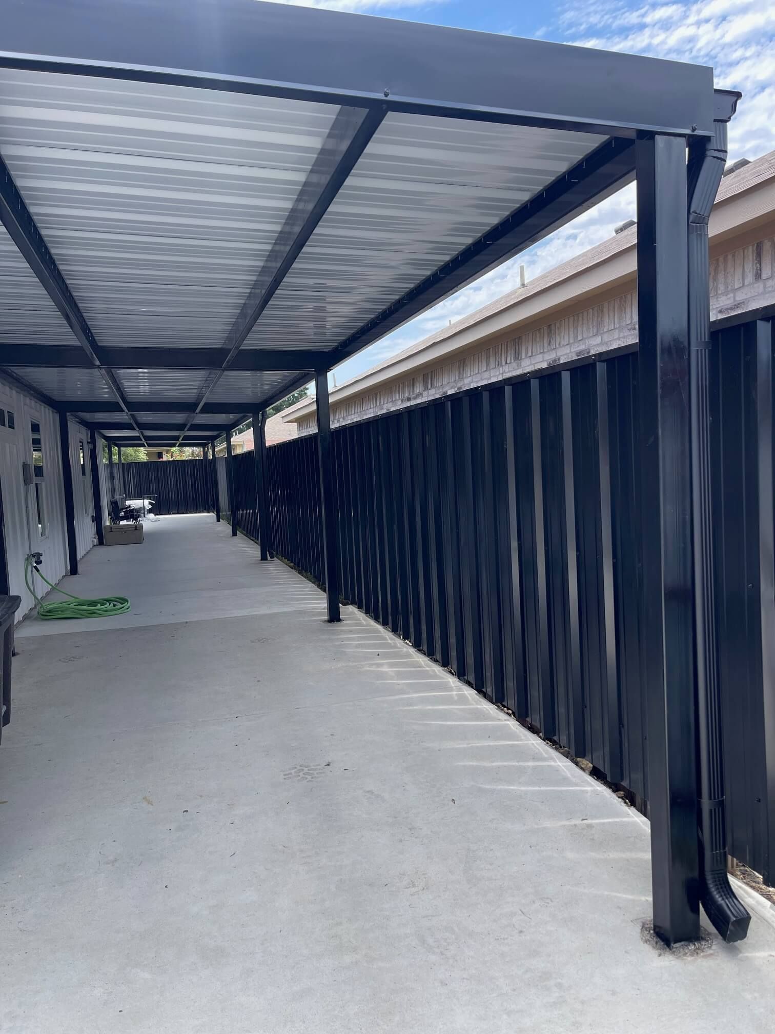 A Long Walkway with A Canopy Over It and A Black Fence