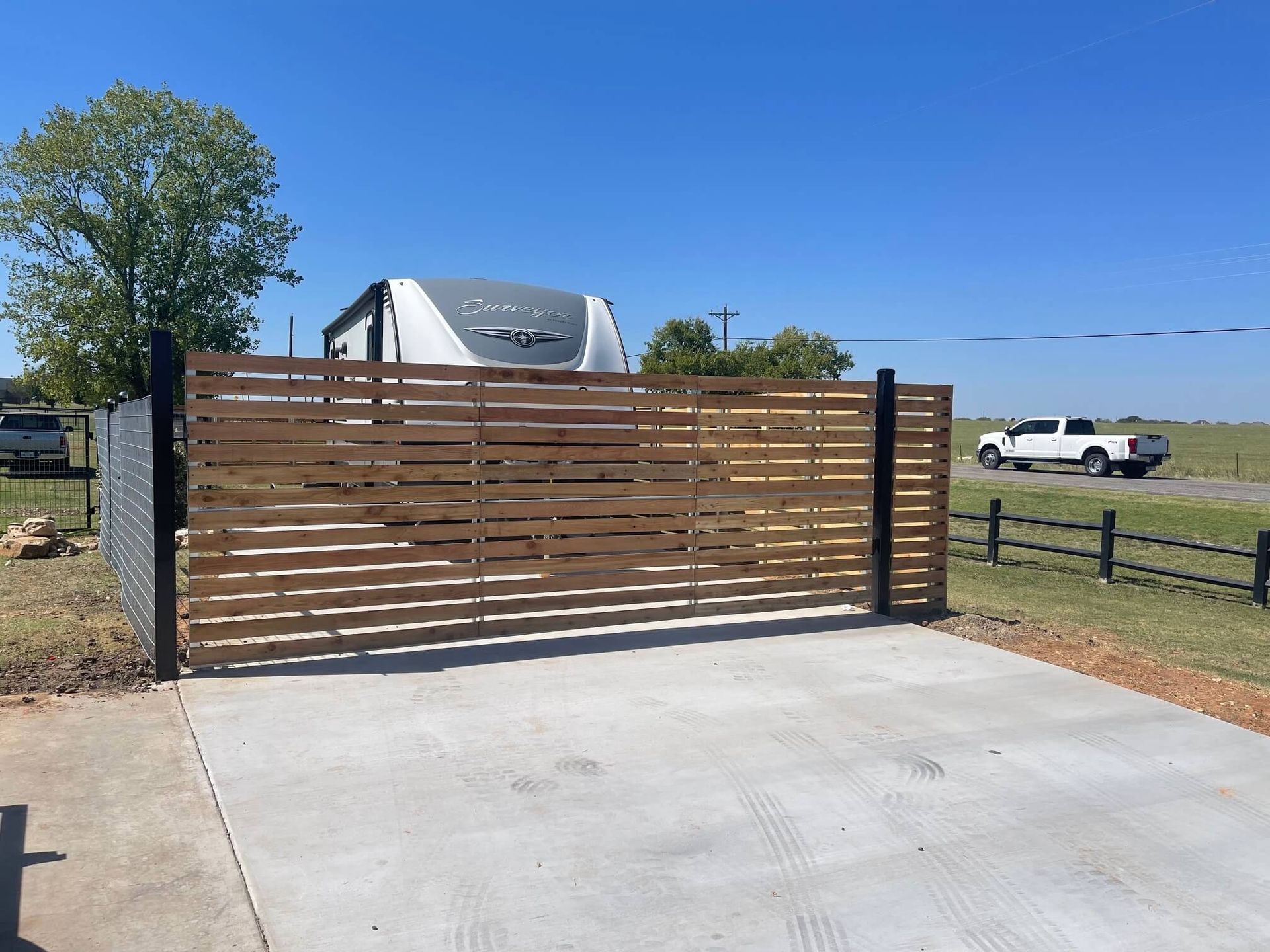 A White Truck Is Parked in Front of A Wooden Gate