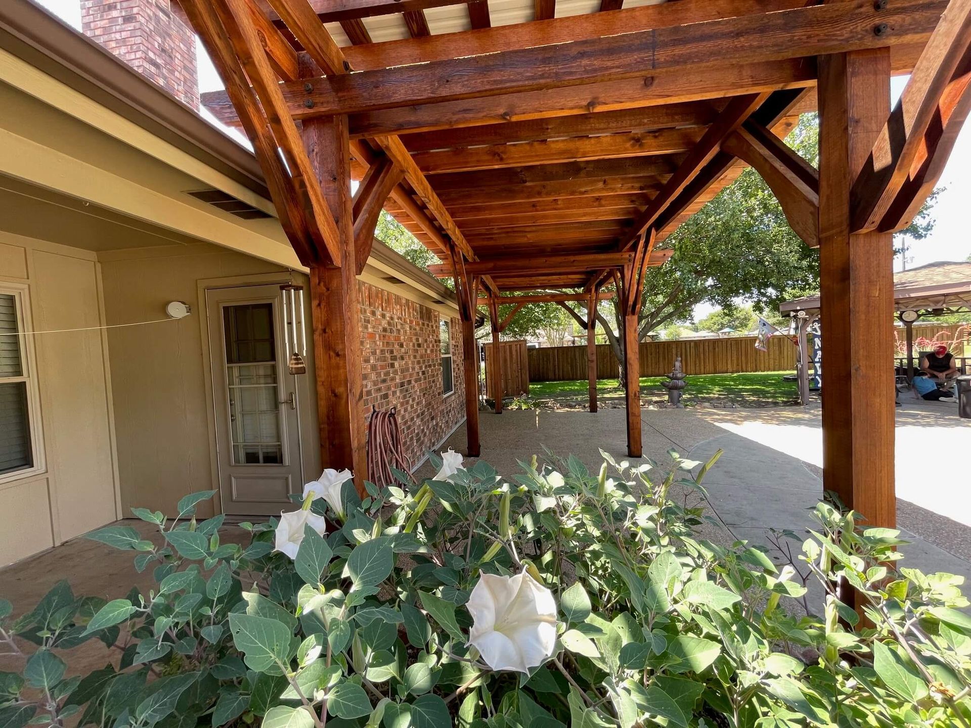 A House with A Wooden Pergola and Flowers in Front of It