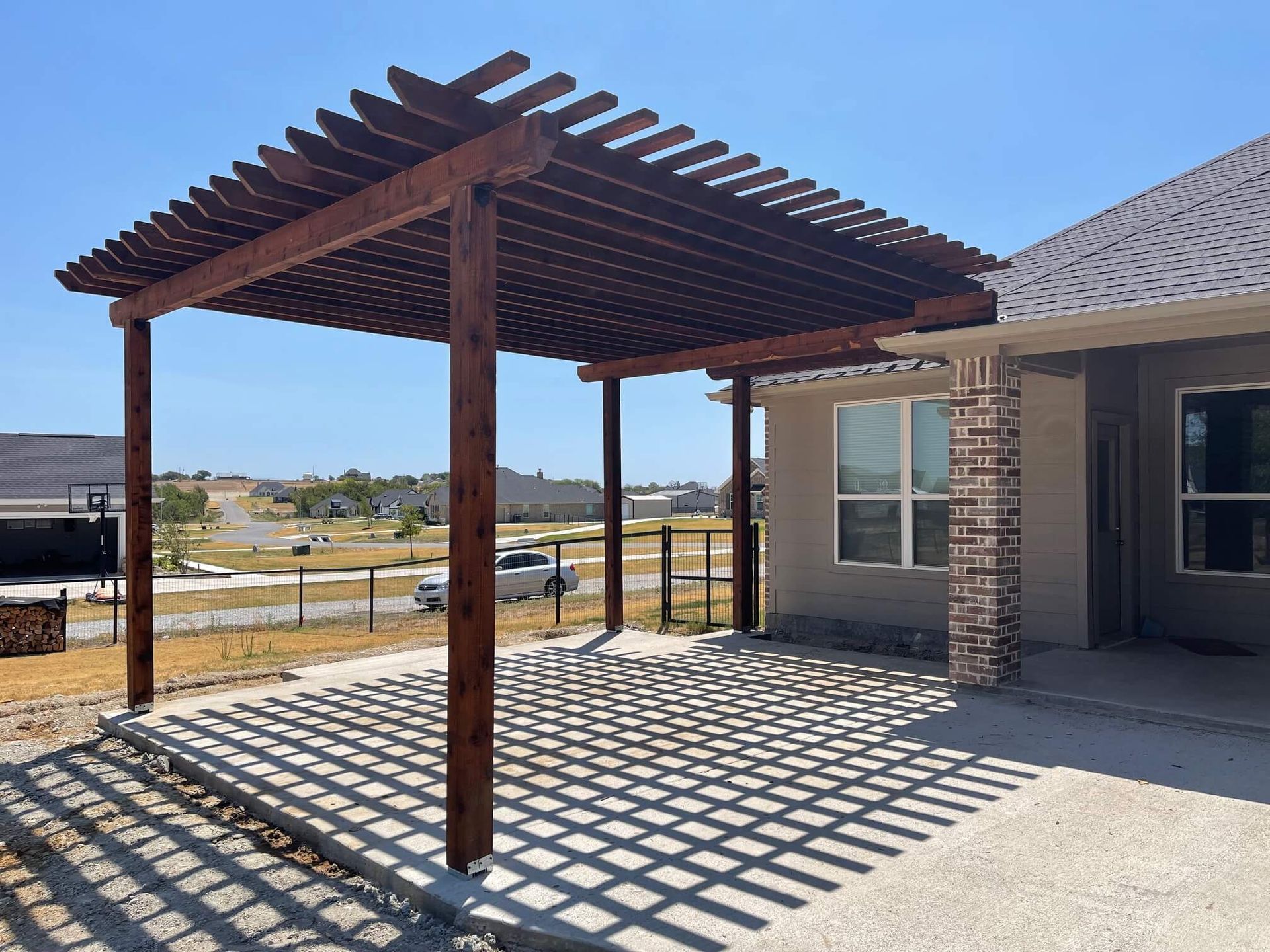 A Wooden Pergola Is Sitting in Front of A House