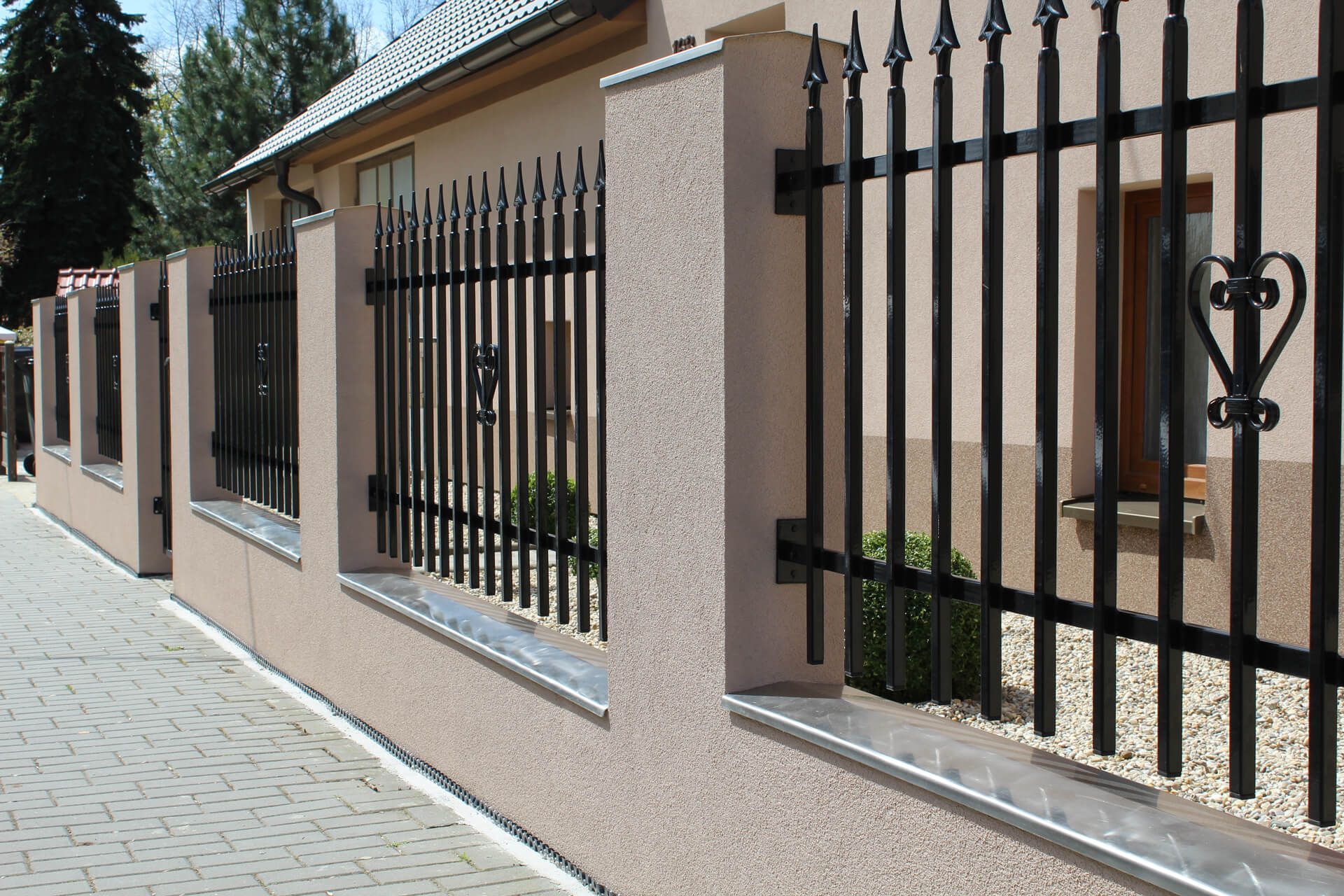 Wrought Iron Fence Surrounds a House on A Sidewalk