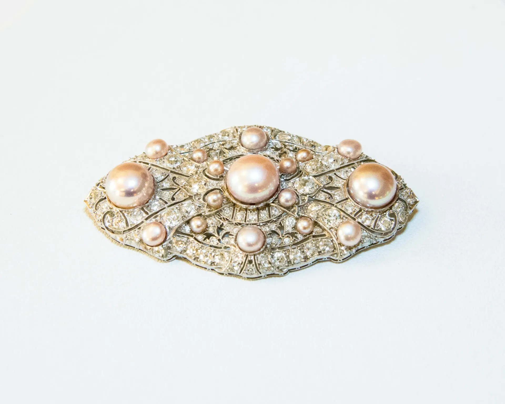 Pearl-studded oval brooch with gold and silver detailing on a white background