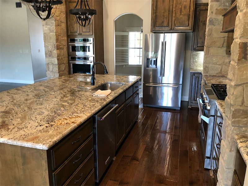 Kitchen with granite countertops, stainless steel appliances, and dark wood cabinets.