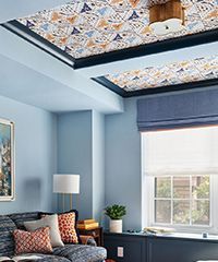 Blue room with patterned ceiling and blue walls, window with blue shade.