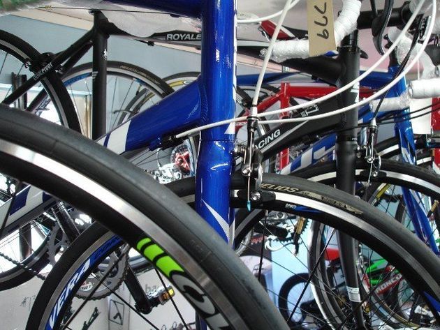 A bunch of bicycles are lined up in a store and one has a tag that says 779 on it