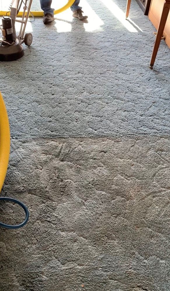 Freshly poured gray concrete floor with construction tools and hoses at the edges