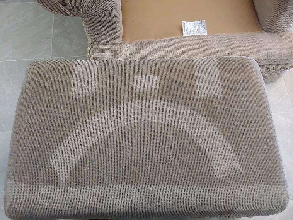 Beige patterned sofa cushions with a light arch design, viewed from above.