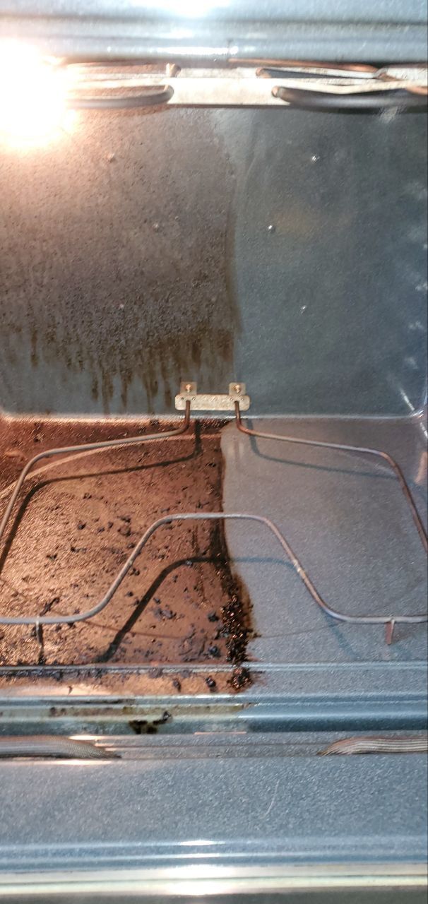 A small brown rabbit in a metal enclosure with a wire floor and reflective walls.