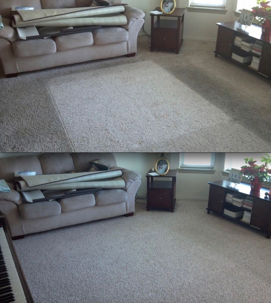 A living room with a beige sofa, carpeted floor, and dark wood furniture.