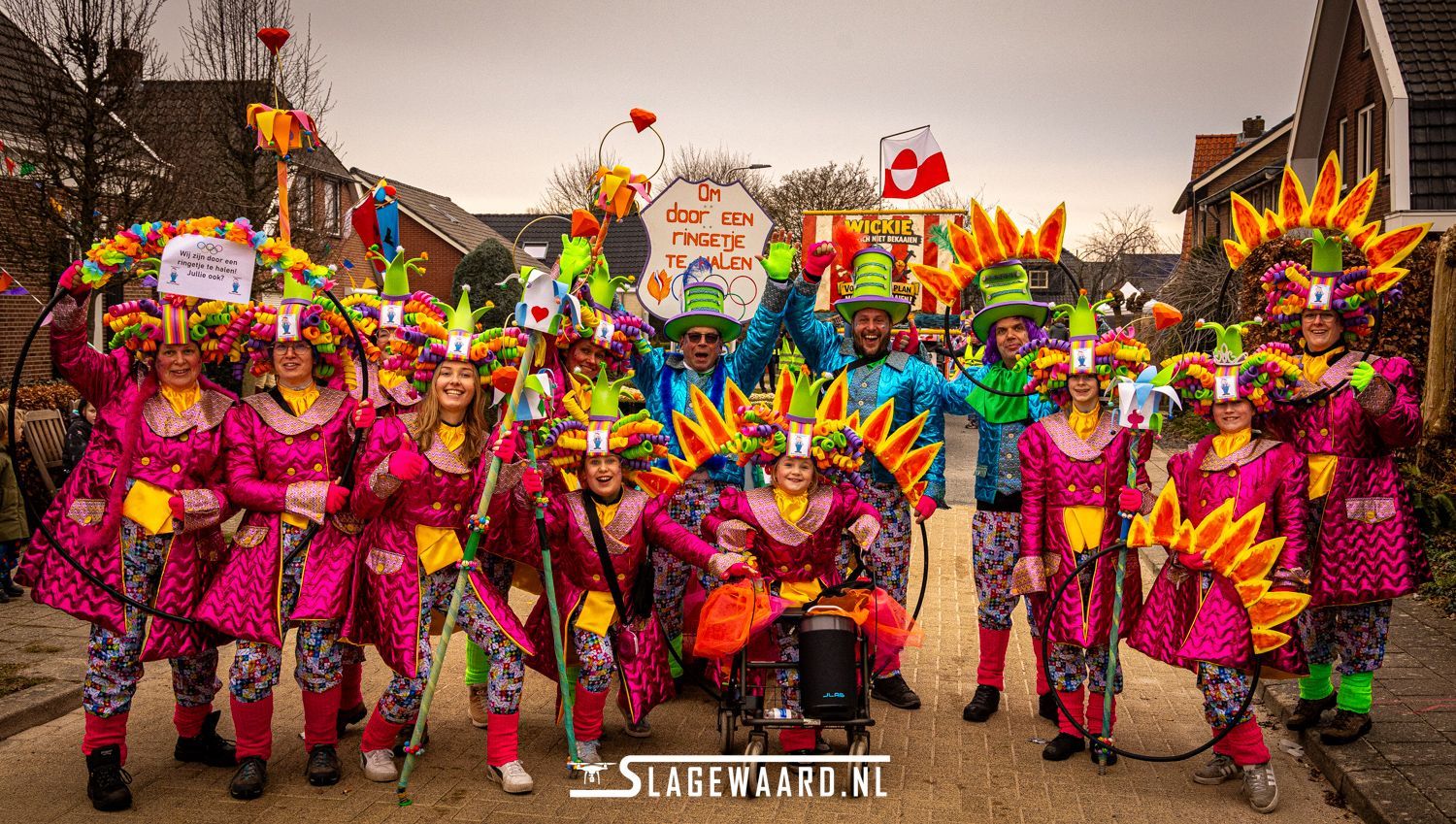 Een groep mensen in opvallende kostuums, Carnaval. Lachend en poserend in de buitenlucht.