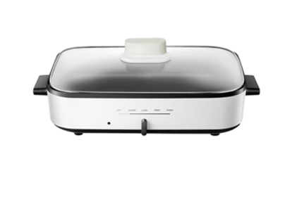 A white pan with a glass lid on a white background