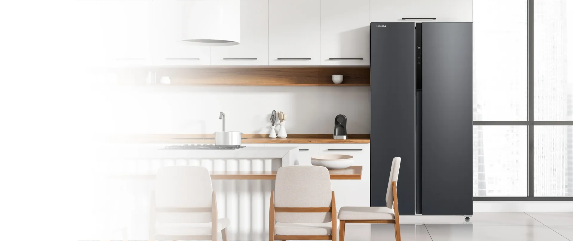A kitchen with a refrigerator and a table and chairs.