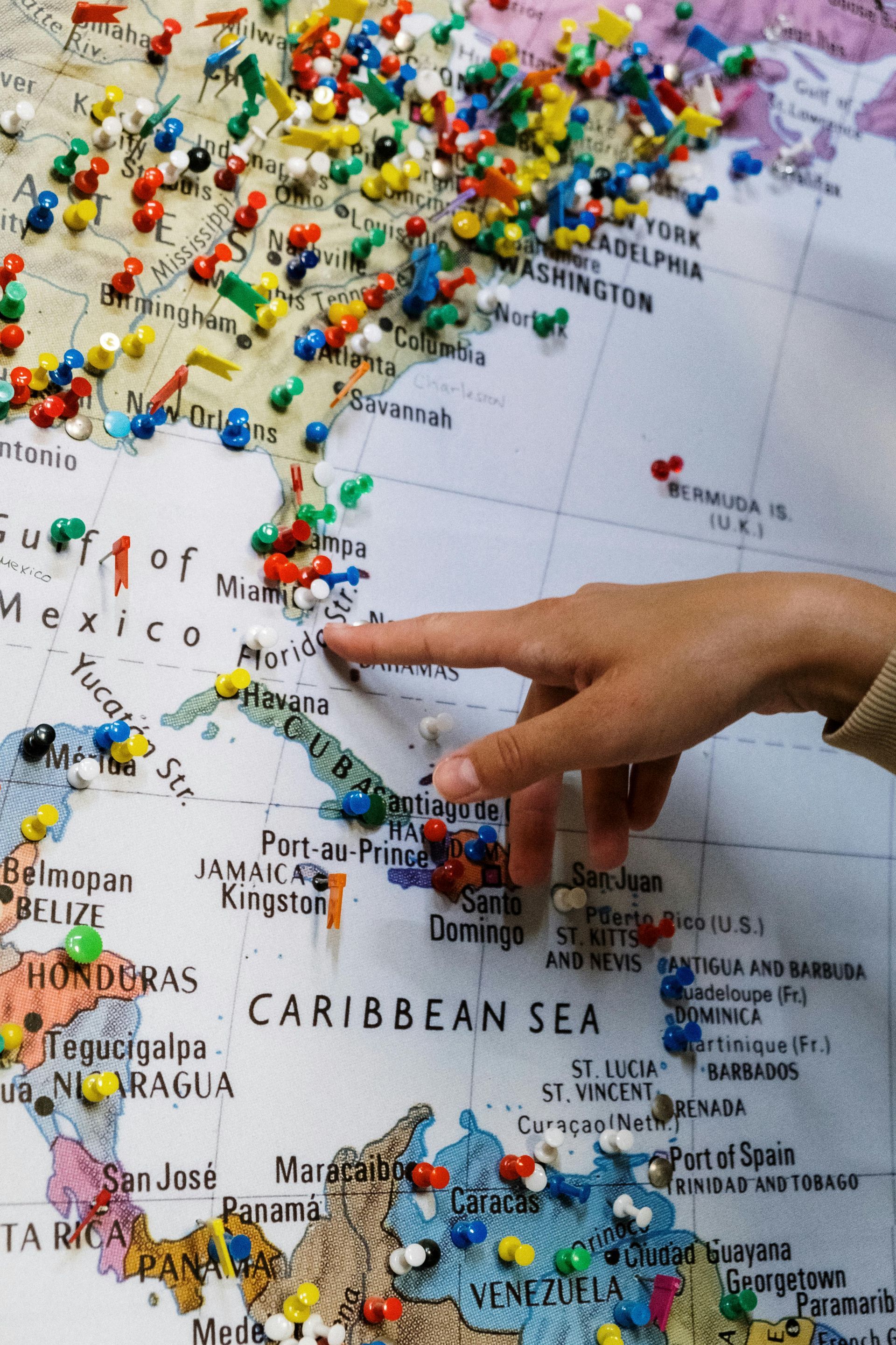 A person is pointing at the caribbean sea on a map