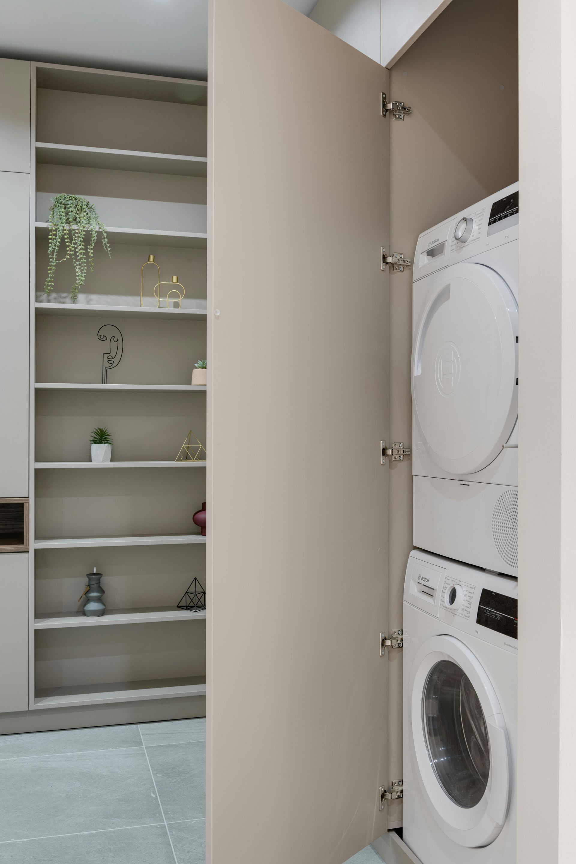 A washer and dryer are stacked on top of each other in a laundry room.