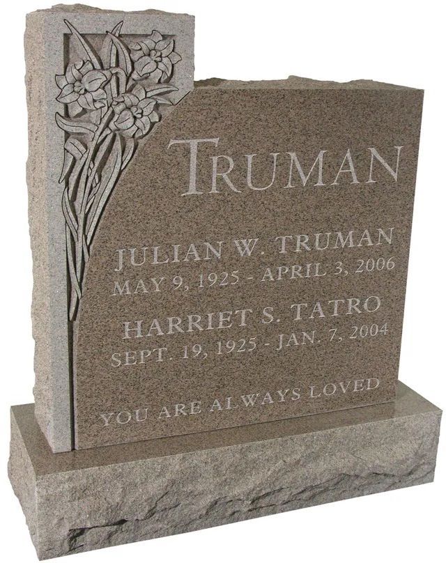 Brown granite memorial gravestone with carved flowers and names Truman and Tatro on a base.
