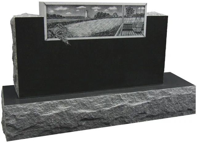Black monument with a small engraved landscape plaque and rough stone base, likely a memorial display