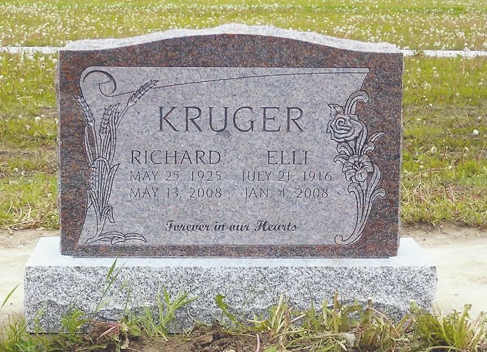 Gray granite gravestone for the Kruger family in a grassy cemetery.