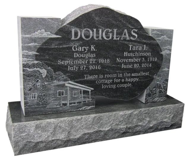 Gray granite memorial headstone engraved “DOUGLAS” with a carved cabin scene and base inscription.