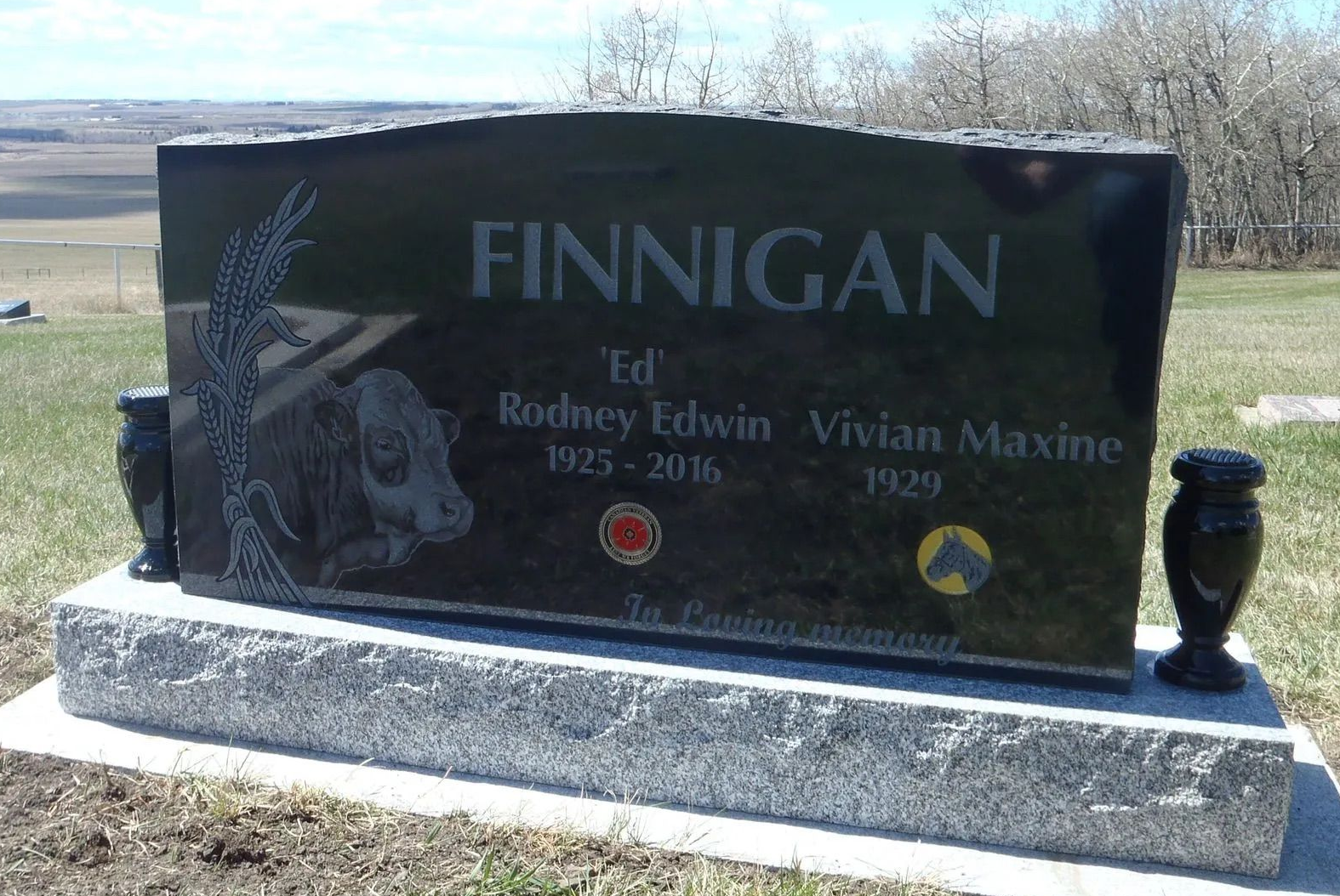 Finnigan family gravestone in a cemetery, black polished stone on a white base with engraved names.
