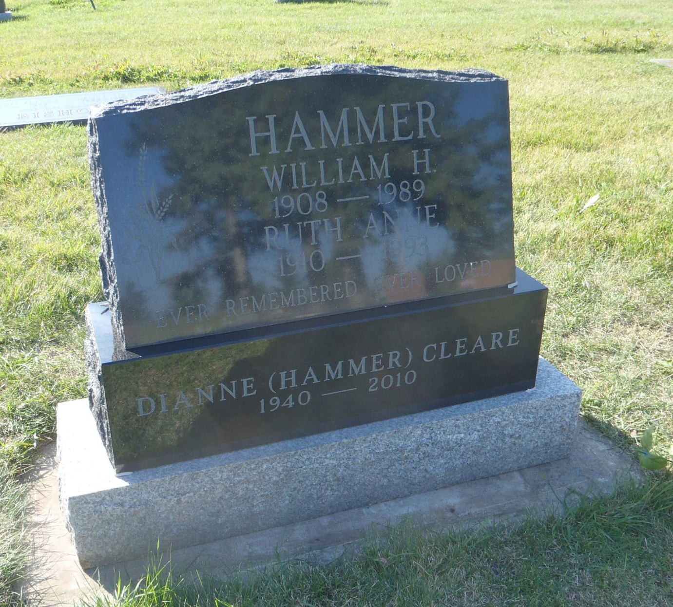 Two-section gravestone on a grassy lawn, engraved