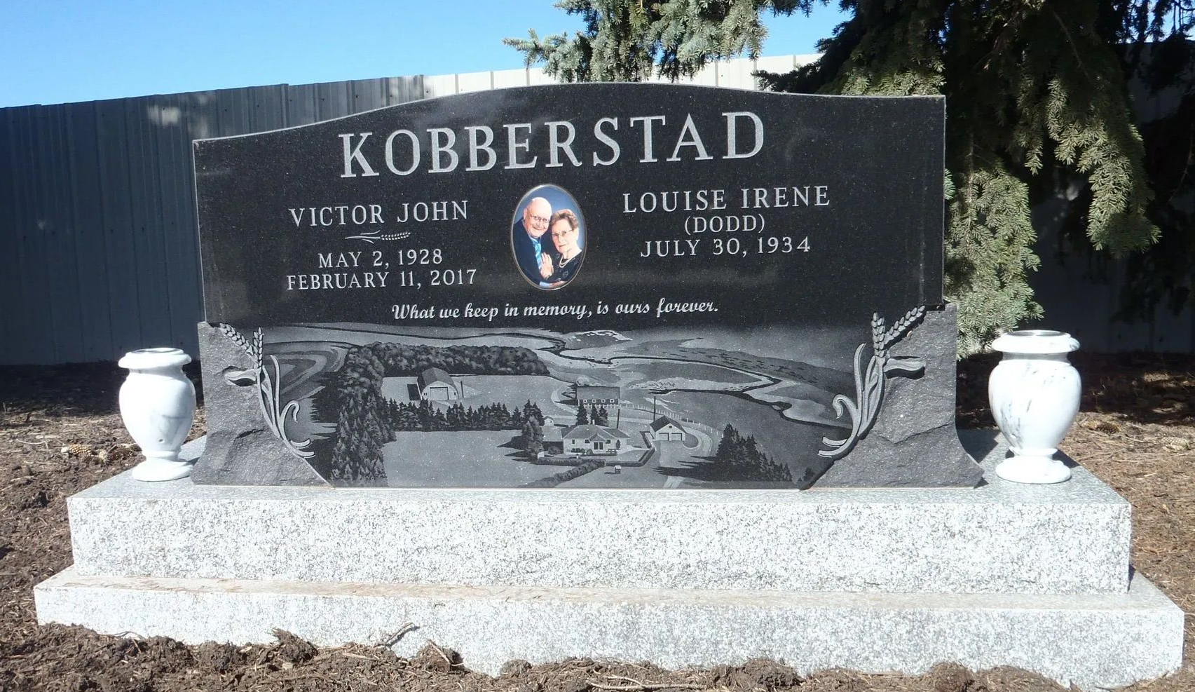 Black headstone with Kobberstad name, birth and death dates of two people, photograph, and decorative elements