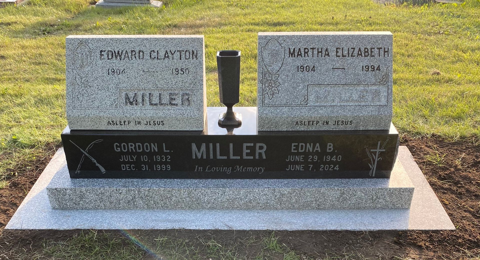 Two granite gravestones with the Miller surname on a polished black base in a grassy cemetery