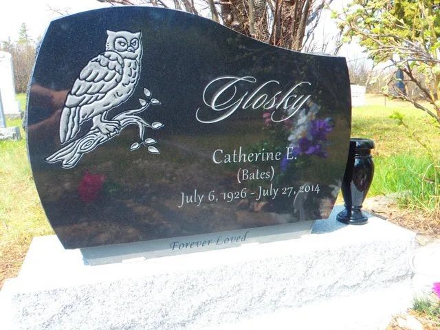 Black headstone with owl engraving and name “Glory,” for Catherine E. Bates, in a cemetery