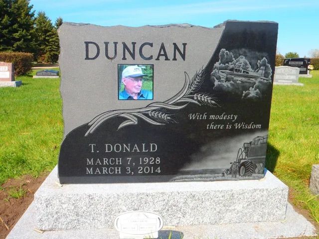 Duncan family gravestone with engraved portrait and names in a cemetery