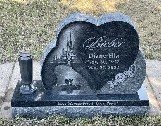 Heart-shaped black gravestone with castle scene and the name Bieber for Diana Ella, in a cemetery.