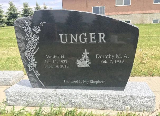 Black granite gravestone engraved “UNGER” in a grassy cemetery.