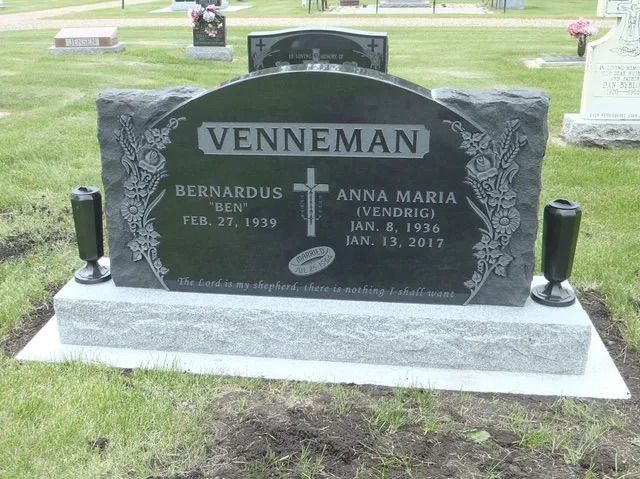 Black granite gravestone with the name Venneman in a cemetery grass setting.