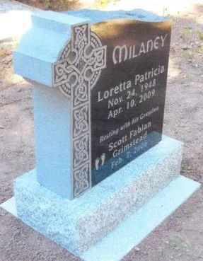 Black granite memorial headstone with Celtic cross engraving on a light blue base