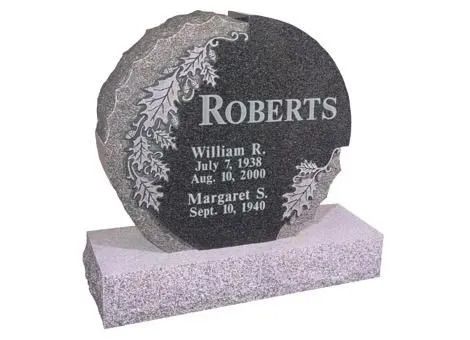 Gray granite upright headstone with carved floral border and the name Roberts on a pink base