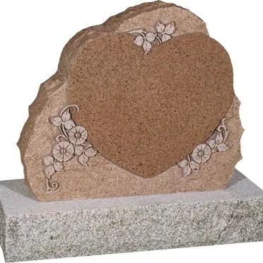 Brown heart-shaped gravestone with floral engraving on a gray base