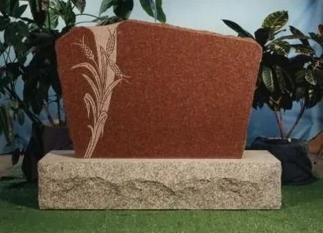 Decorative red planter with a white leaf design on a stone base outdoors